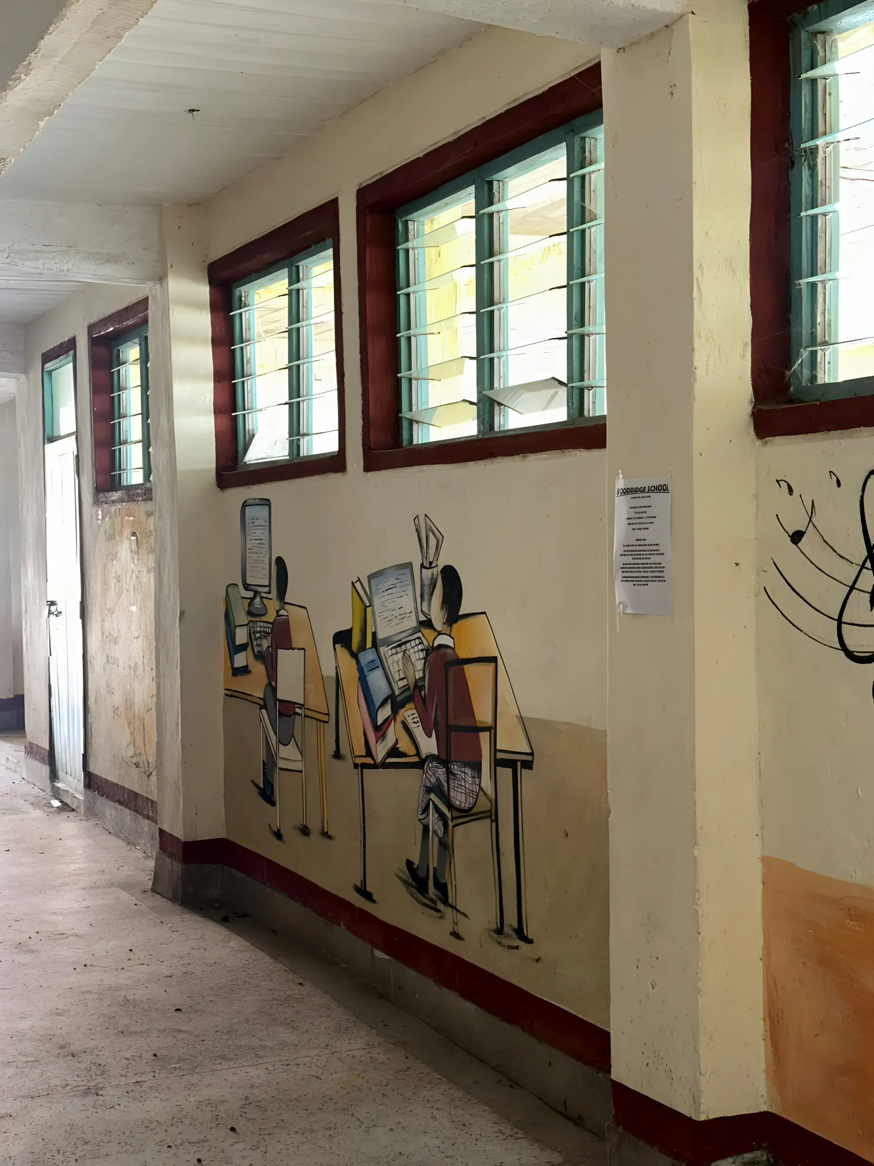 A mural of learners working at computers, painted on a school corridor wall